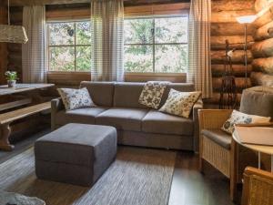 ein Wohnzimmer mit Sofa und Tisch in der Unterkunft Holiday Home Vuokatinportti a4 by Interhome in Lahdenperä