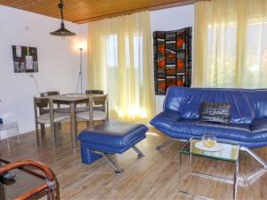 een woonkamer met een blauwe bank en een tafel bij Apartment Chalet Albi by Interhome in Grindelwald