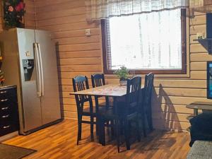cocina con mesa, sillas y nevera en Holiday Home Kitkan lahti by Interhome en Kesäniemi