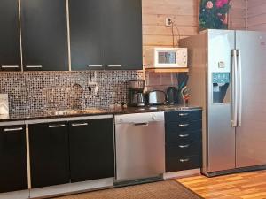 una cocina con electrodomésticos de acero inoxidable y armarios negros en Holiday Home Kitkan lahti by Interhome en Kesäniemi