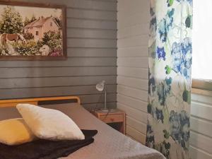 1 dormitorio con 1 cama y una pintura en la pared en Holiday Home Kitkan lahti by Interhome en Kesäniemi