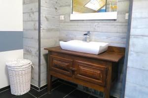 uma casa de banho com um lavatório branco e um espelho. em L'Ôberge em Arlos
