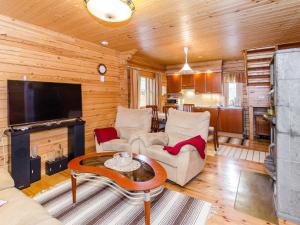 a living room with a couch and a tv and a table at Holiday Home Rantakumpu by Interhome in Lieksa