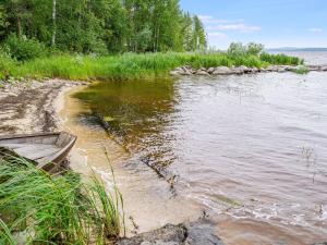 a boat on the shore of a body of water at Holiday Home Rantakumpu by Interhome in Lieksa