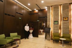 a mannequin standing in a waiting room with green chairs at Paris Plaza Hotel in Erbil