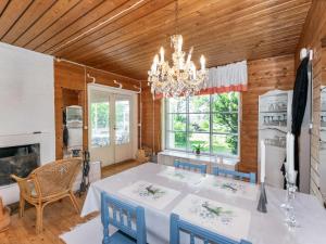 a dining room with a table and a chandelier at Holiday Home Lampaluodon punainen tupa by Interhome in Tyltty