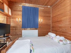 a bedroom with a bed with a blue curtain at Holiday Home Lampaluodon punainen tupa by Interhome in Tyltty