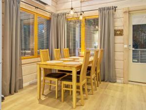 uma sala de jantar com uma mesa de madeira e cadeiras em Holiday Home Pikku-hovila by Interhome em Tahkovuori