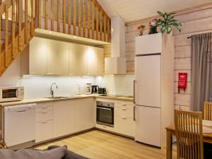 eine Küche mit weißen Schränken und einem Kühlschrank in der Unterkunft Holiday Home Pikku-hovila by Interhome in Tahkovuori