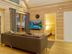 ein Wohnzimmer mit Couch und Flachbildfernseher in der Unterkunft Holiday Home Pikku-hovila by Interhome in Tahkovuori + 16 Fotos