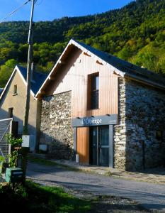 - un petit bâtiment en pierre avec un panneau dans l'établissement L'Ôberge, à Arlos