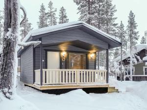 a small cabin with a porch in the snow at Holiday Home Pikkuporo b by Interhome in Saariselka