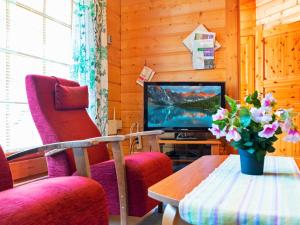 LahdenperäにあるHoliday Home Otso by Interhomeのリビングルーム(テレビ、椅子2脚、テーブル付)