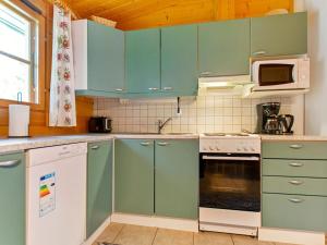 LahdenperäにあるHoliday Home Otso by Interhomeのキッチン(緑のキャビネット、コンロ付) 上部オーブン