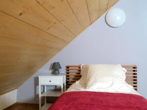 a bedroom with a bed with a wooden ceiling at L'Ôberge in Arlos