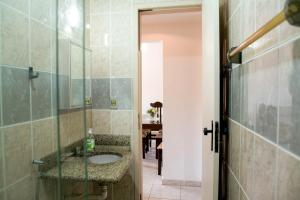 uma casa de banho com um lavatório e uma cabina de duche ao nível do chão em Ótimo apartamento na Praia dos Castelhanos com Wi-Fi em Anchieta