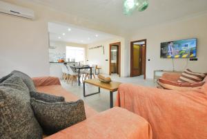 sala de estar con 2 sofás y TV en la pared en Can Biel, en Pina
