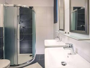 a bathroom with two sinks and a glass shower at Holiday Home Residence Lipno-1 by Interhome in Lipno nad Vltavou