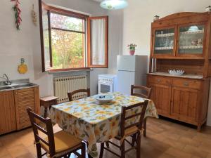 kuchnia ze stołem, krzesłami i lodówką w obiekcie Apartment Sonia by Interhome w mieście Riparbella
