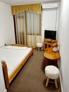 a bedroom with a bed and a desk with a computer at Motel Thessaloniki in Sandanski