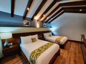 2 letti in camera d'albergo con di Casa San Miguel Hotel Boutique y Spa a Zacatlán
