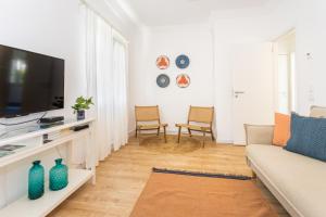 ein Wohnzimmer mit Couch und Flachbildfernseher in der Unterkunft CASA AROEIRA - Beach bungalow near Lisbon in Charneca