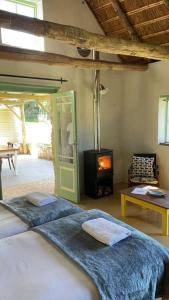 - une chambre avec un lit et une cheminée dans l'établissement Paddahoek Cottage, à Vermaaklikheid