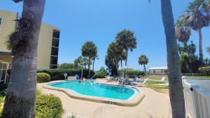 una piscina en un complejo con palmeras en Beach Front One Bedroom Condo Paradise. Ground Floor., en Longboat Key