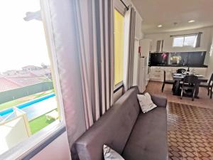 Una sala de estar con un sofá y una ventana grande. en CASA DOS AVÓS Apartments with Pool in Funchal, en Funchal