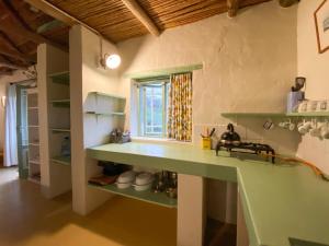 eine Küche mit grünen Regalen und einem Fenster in der Unterkunft Paddahoek Cottage in Vermaaklikheid