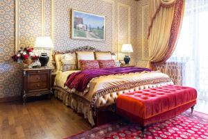 um quarto com uma cama e um repousa-pés vermelhos em Suter Palace Heritage Boutique Hotel em Bucareste