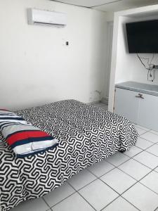 a bedroom with a bed with a black and white comforter at La casa de la luna in Antón Lizardo