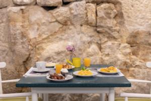 a table with plates of food and glasses of orange juice at Legendary Porto Hotel in Porto