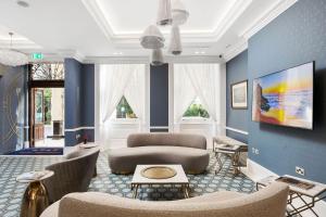 a living room with blue walls and chairs at Commodore Hotel in London