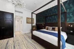 1 dormitorio con 1 cama grande y cabecero grande en Commodore Hotel en Londres