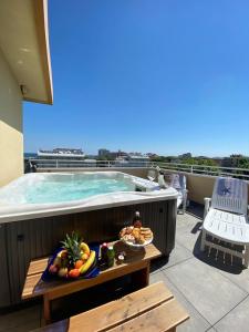 a swimming pool with a tray of fruit on a balcony at Hotel Maioli B&B in Misano Adriatico