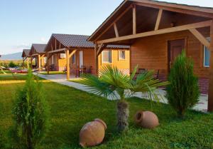 ein Haus mit einer Palme im Hof in der Unterkunft Finca Idoize Camping Hotel in Akhmety