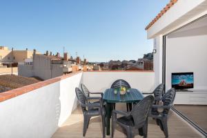 a patio with a table and chairs on a balcony at Hauzify I Apartament 4Winds in Sant Feliu de Guixols