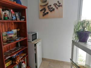 een keuken met een boekenplank en een magnetron bij Chambres d hôtes Chez Valérie et Bernard in Nissan-lez-Enserune