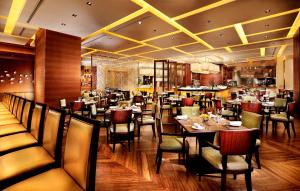 a restaurant with tables and chairs in a room at Four Seasons Hotel Macao in Macau