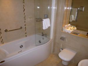 y baño con bañera, aseo y lavamanos. en International Hotel Killarney en Killarney