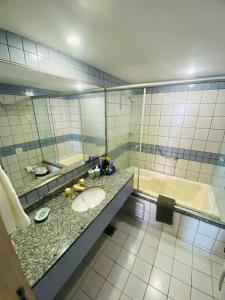 uma casa de banho com um lavatório, uma banheira e um espelho. em Vista do Mucuripe em Fortaleza