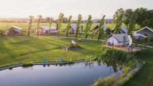 - une vue aérienne sur un complexe avec un lac et des tentes dans l'établissement Glamping Kolpa Resort, à Gradac