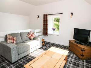 a living room with a couch and a tv at Gorrie's Lair in Spean Bridge