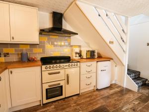 a kitchen with a stove top oven next to a staircase at Gorrie's Lair in Spean Bridge