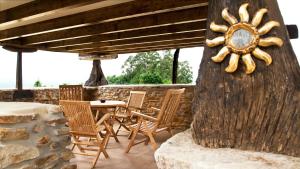 eine Terrasse mit einem Tisch, Stühlen und einem Baum in der Unterkunft La Casa de la Abuela Milagros in Pravia
