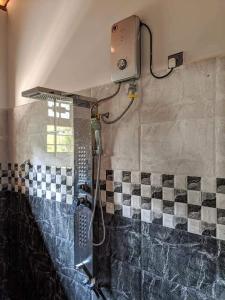 a shower in a bathroom with black and white tiles at Blooming Villa & Guest in Matara +12 photos