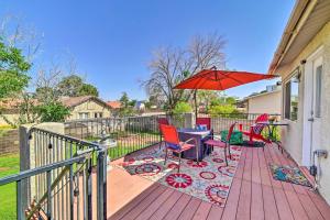 a deck with a table and chairs and an umbrella at 1 Mi to Canyon Tours Vibrant Page Paradise! in Page