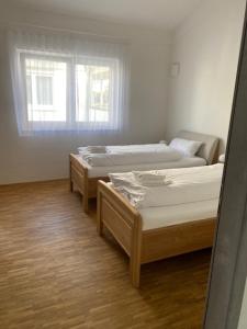 twee bedden in een kamer met een raam bij Appartement 17 in Oerlinghausen