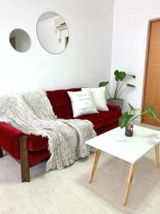- un salon avec un canapé rouge et une table dans l'établissement Venezia Aparts, à Colón